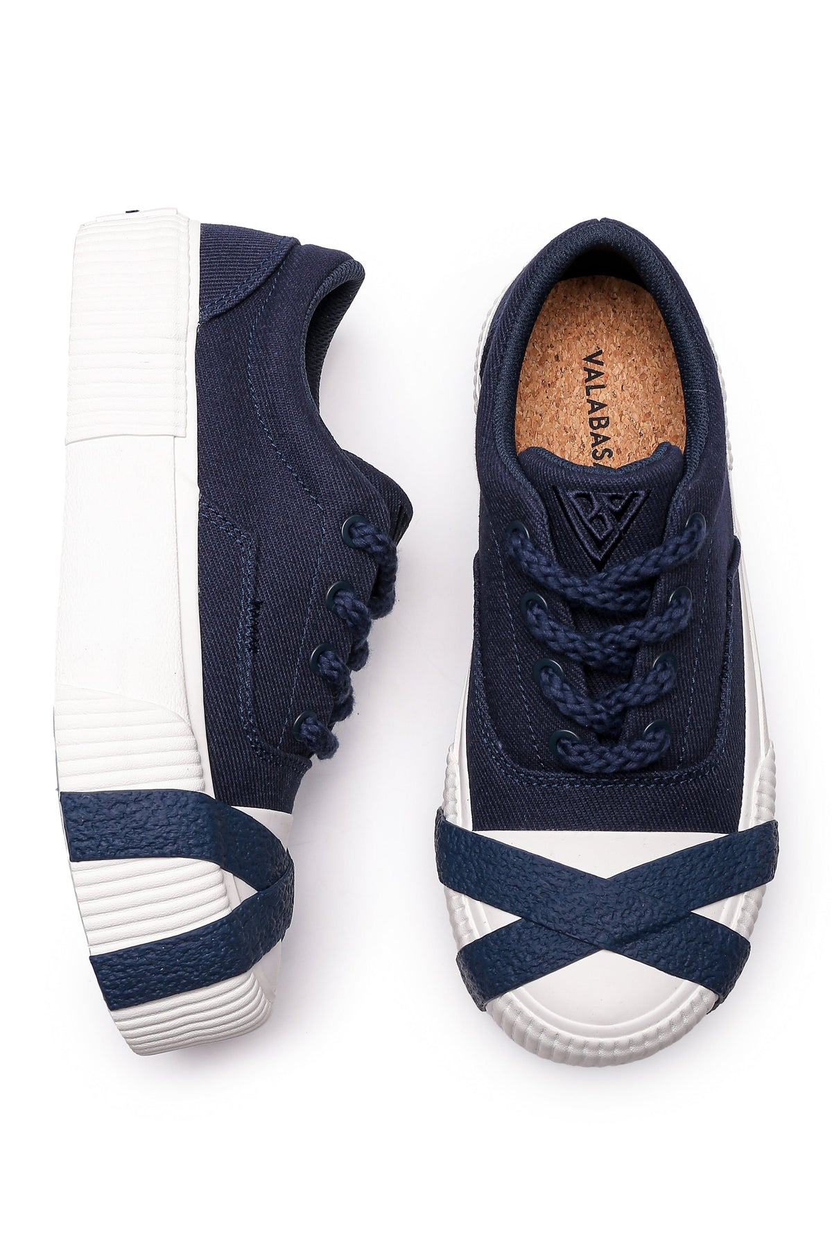 Pair of navy blue sneakers with white soles on a white background
